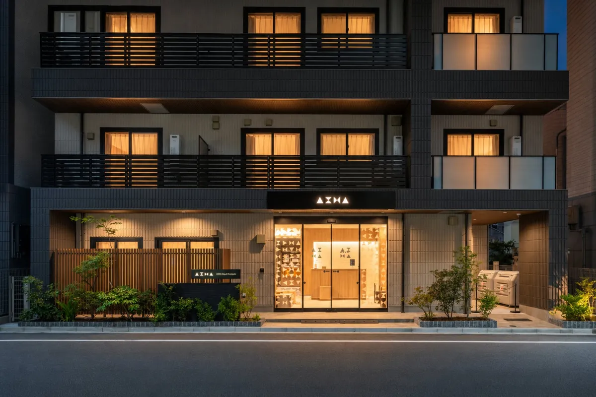 조명이 켜진 AIMA Tokyo Kinshicho 호텔의 현대적인 야간 외관