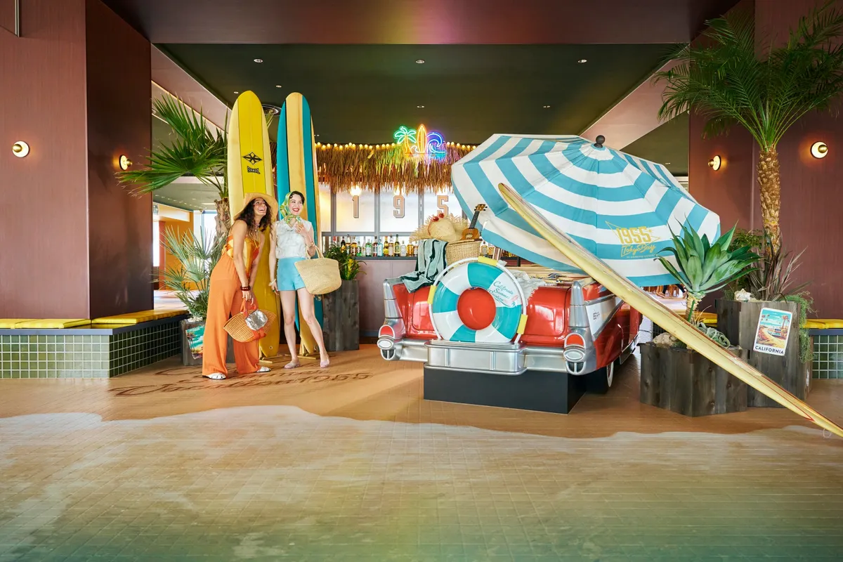 Retro lobby installation with surfboards and a classic car