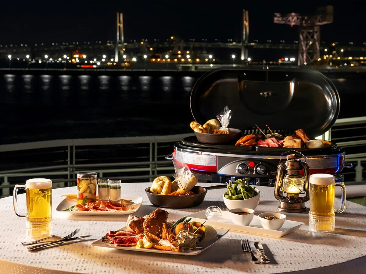 Outdoor BBQ table at night with harbor views