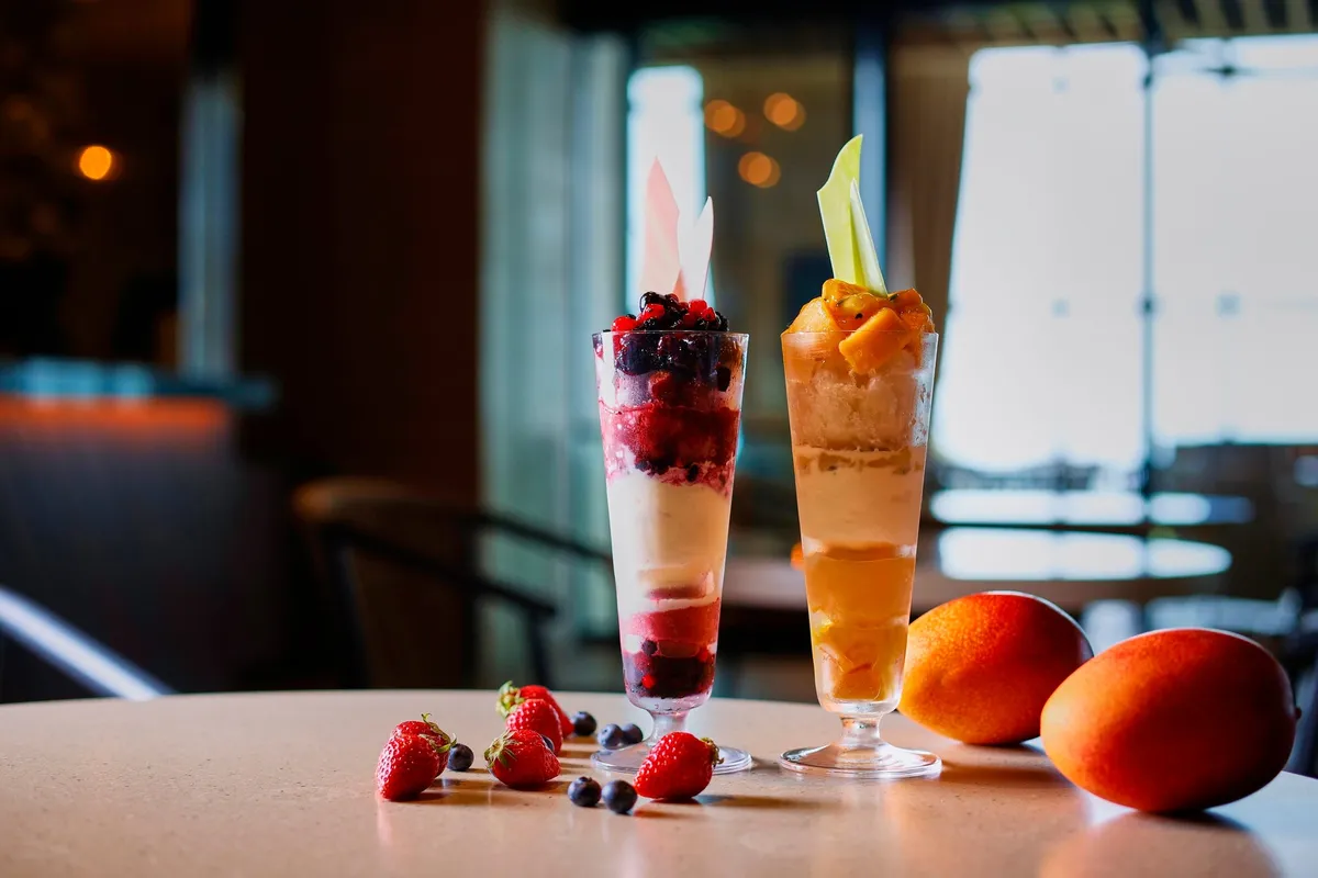 Two artisanal parfaits featuring berries and mango
