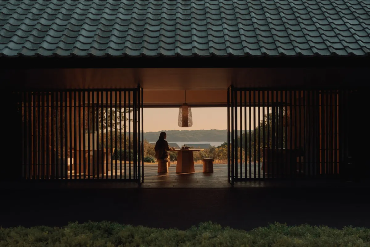 A guest at a table framed by the resort's architecture overlooking Ago Bay
