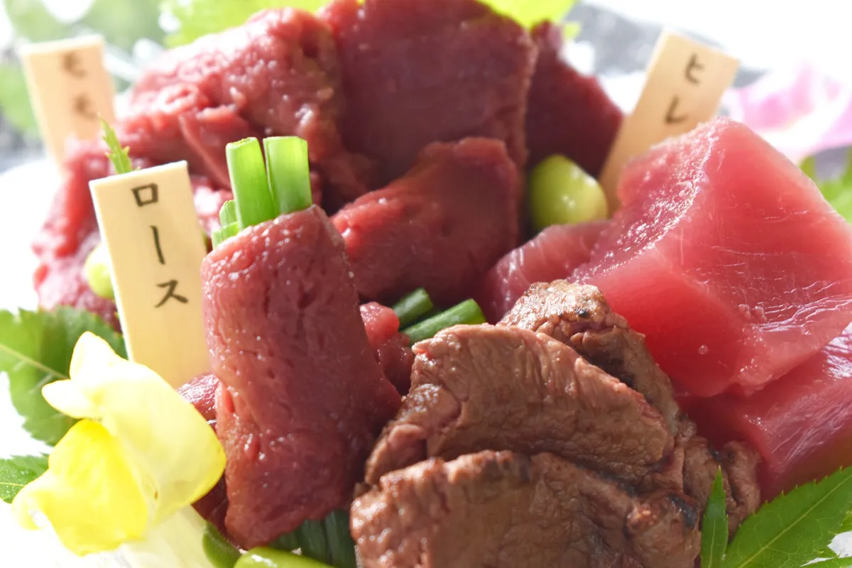 Three cuts of basashi served with traditional garnishes
