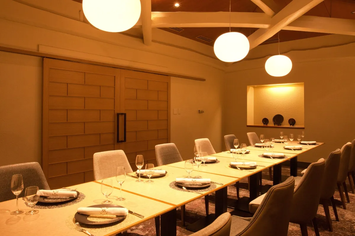 A private dining room with warm lighting and a long table