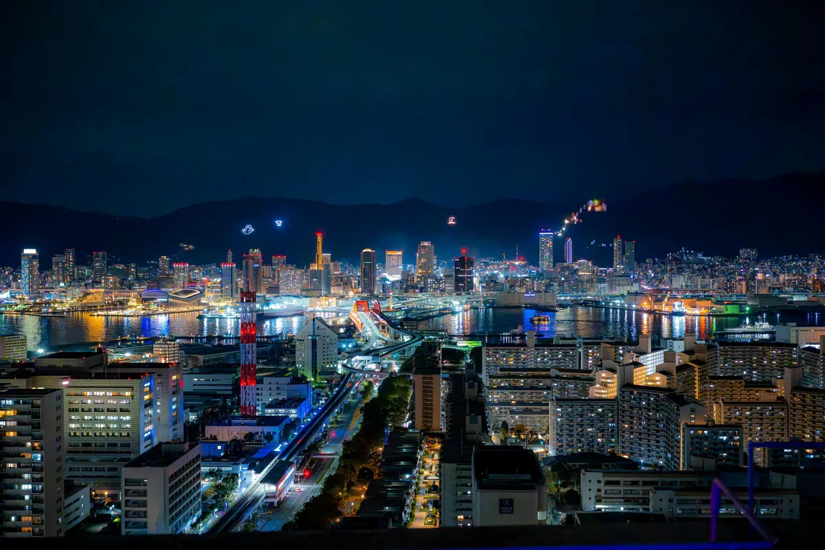 A wide night view of the Kobe port and city skyline from above