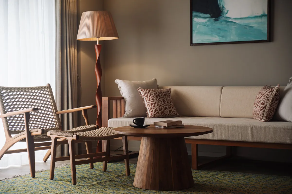 A guest room interior with a wooden table, sofa, and art