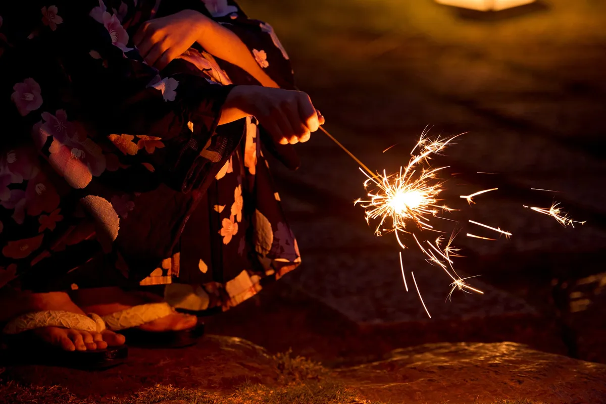Close-up of a handheld sparkler during a summer evening