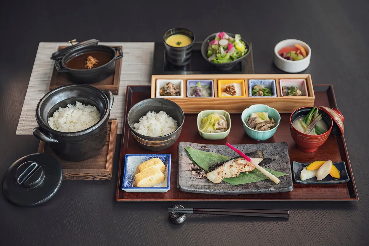 A traditional Japanese breakfast set with grilled fish and small side dishes