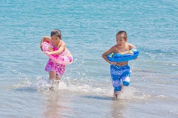 Children playing in the surf at AoAwo Naruto Resort