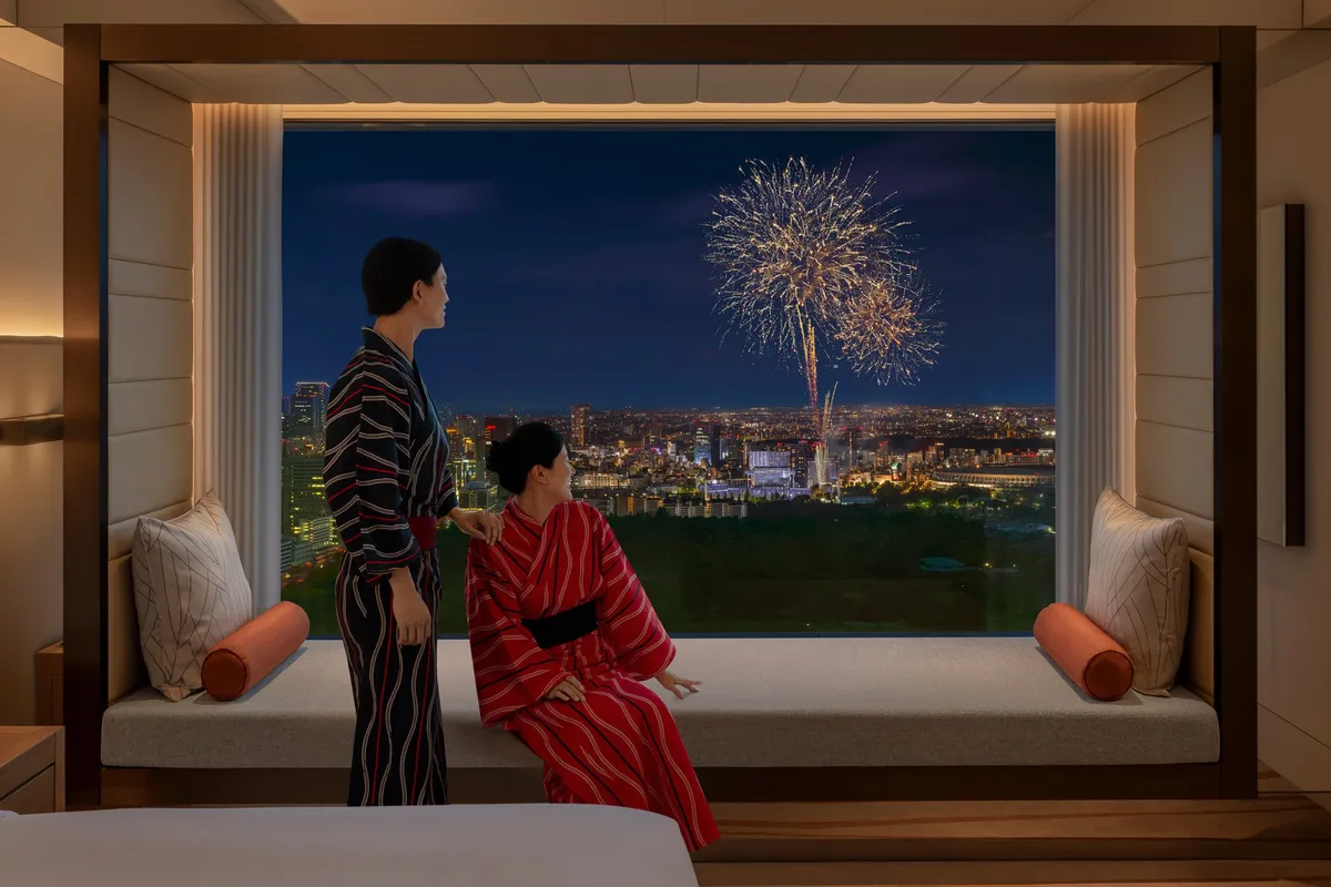 Guests in yukata viewing fireworks from a window seat