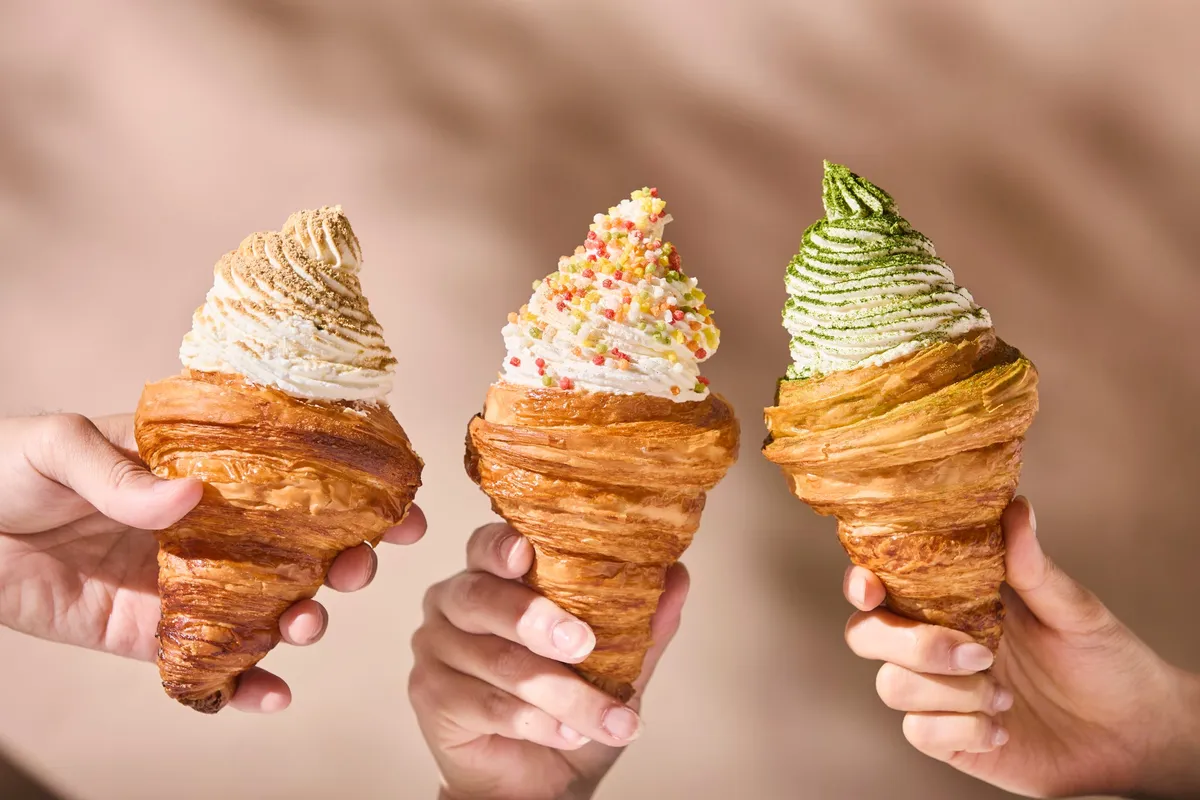 Three varieties of croissant soft serve held in hands