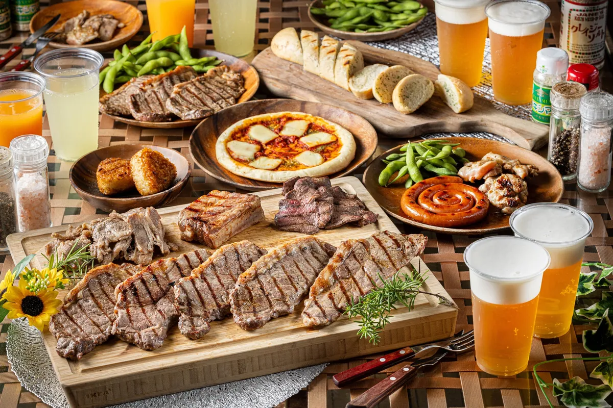 A spread of grilled meats, pizza, and side dishes at the rooftop BBQ