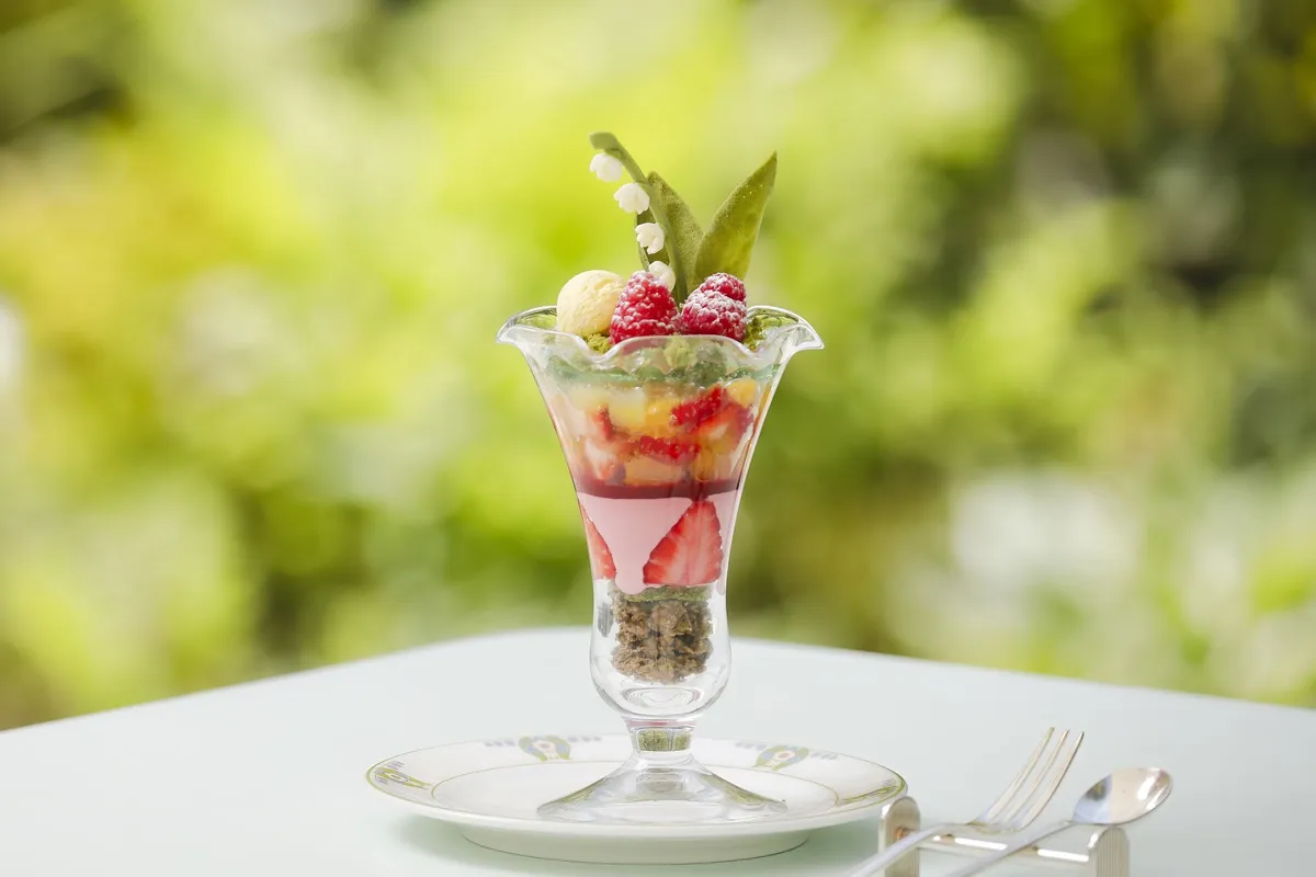 A multi-layered parfait topped with chocolate lily-of-the-valley flowers