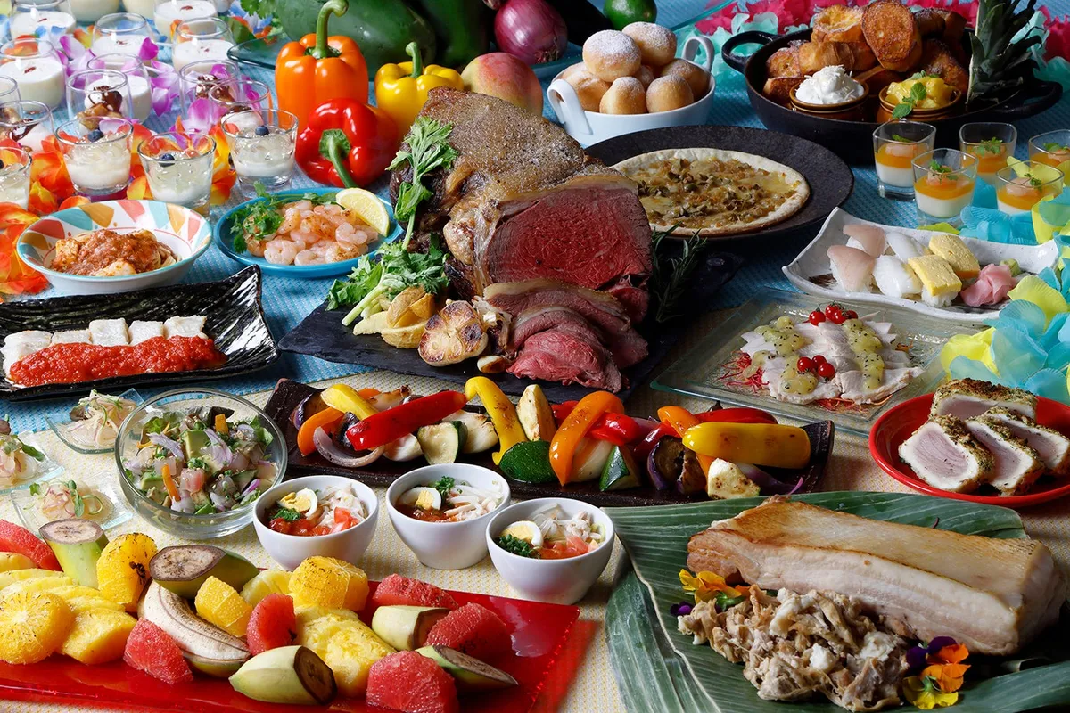 A diverse buffet spread at COOKA including roasted beef and tropical fruit