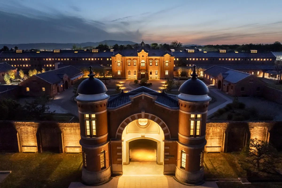 The illuminated gate and main building of HOSHINOYA Nara Prison at dusk