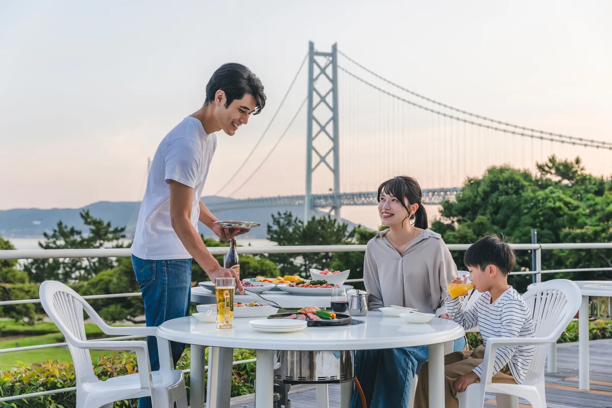 Family dining on the hotel terrace with the Akashi Kaikyo Bridge in the background