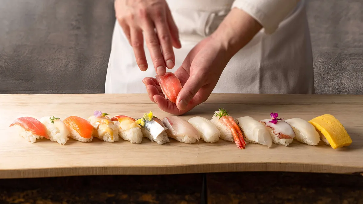A chef hand-crafting sushi at the live station