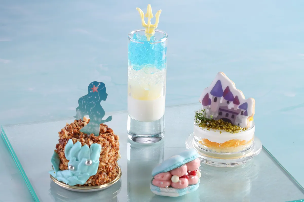 Close-up of the top-tier sweets featuring a trident and mermaid silhouette