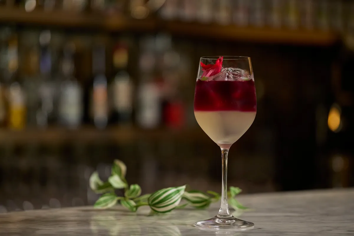 A layered Citrus Rouge Tea non-alcoholic cocktail at the bar