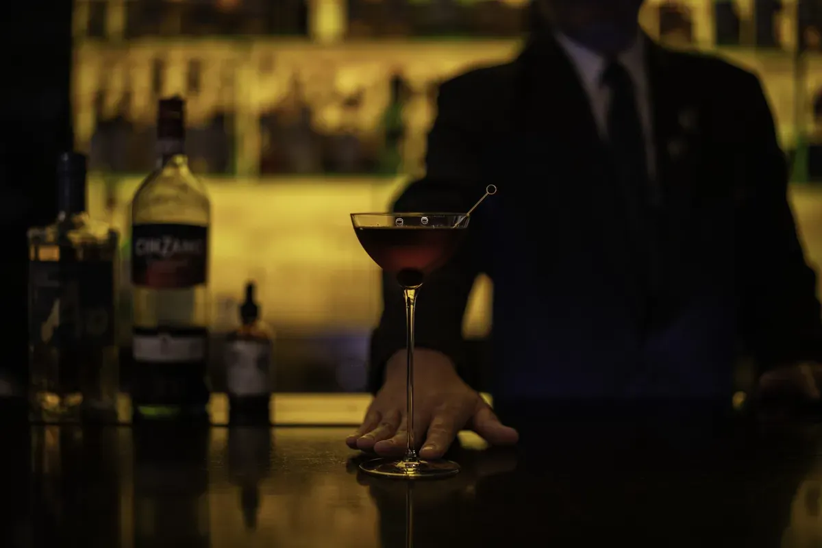 A bartender preparing a cocktail at the bar
