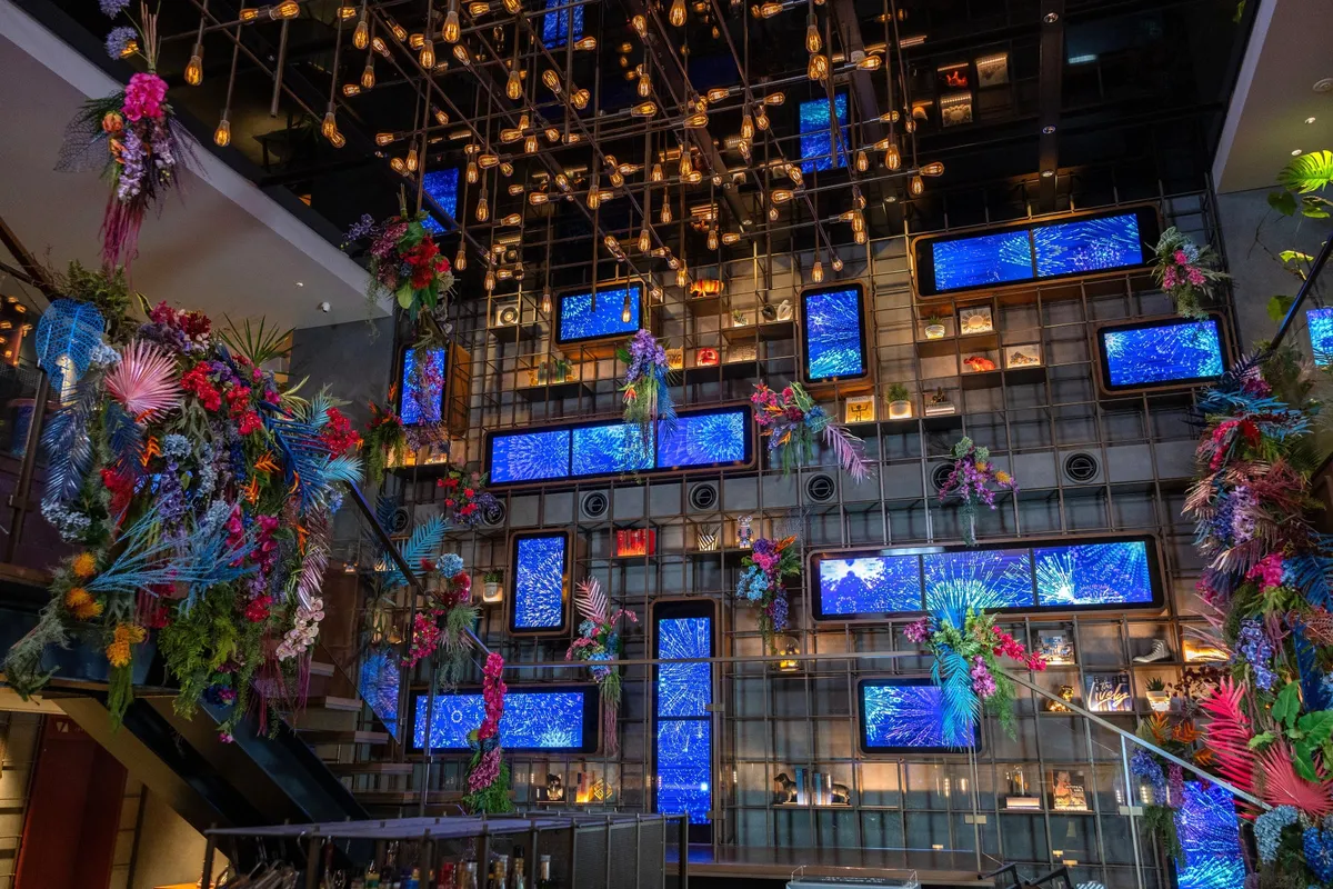 Wide view of the lobby with digital screens and flowers