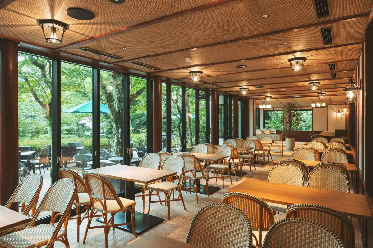 The interior of the Cafe Terrace with wicker chairs and large windows