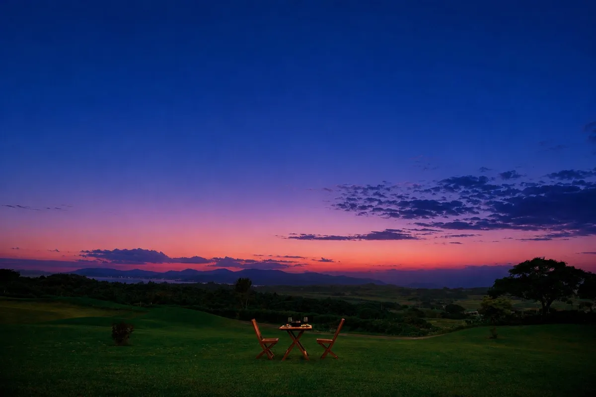 Table set for dinner against a purple and orange sunset