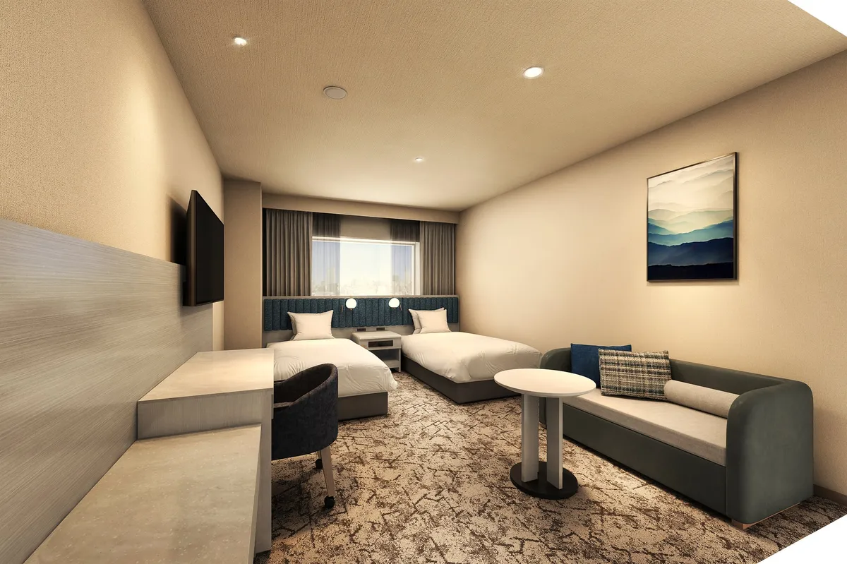 A modern guest room with neutral tones and functional workspace