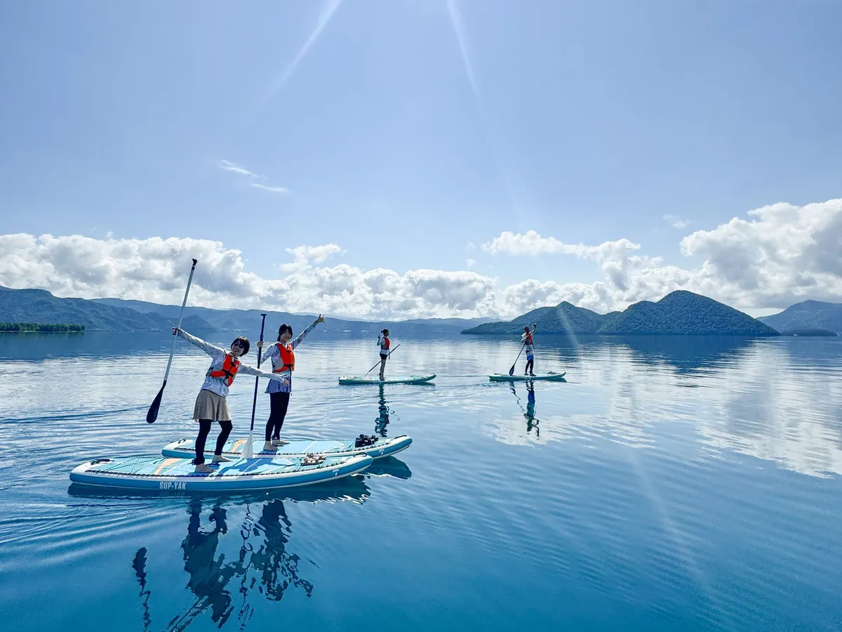 Paddleboarders on the calm surface of Lake Toya
