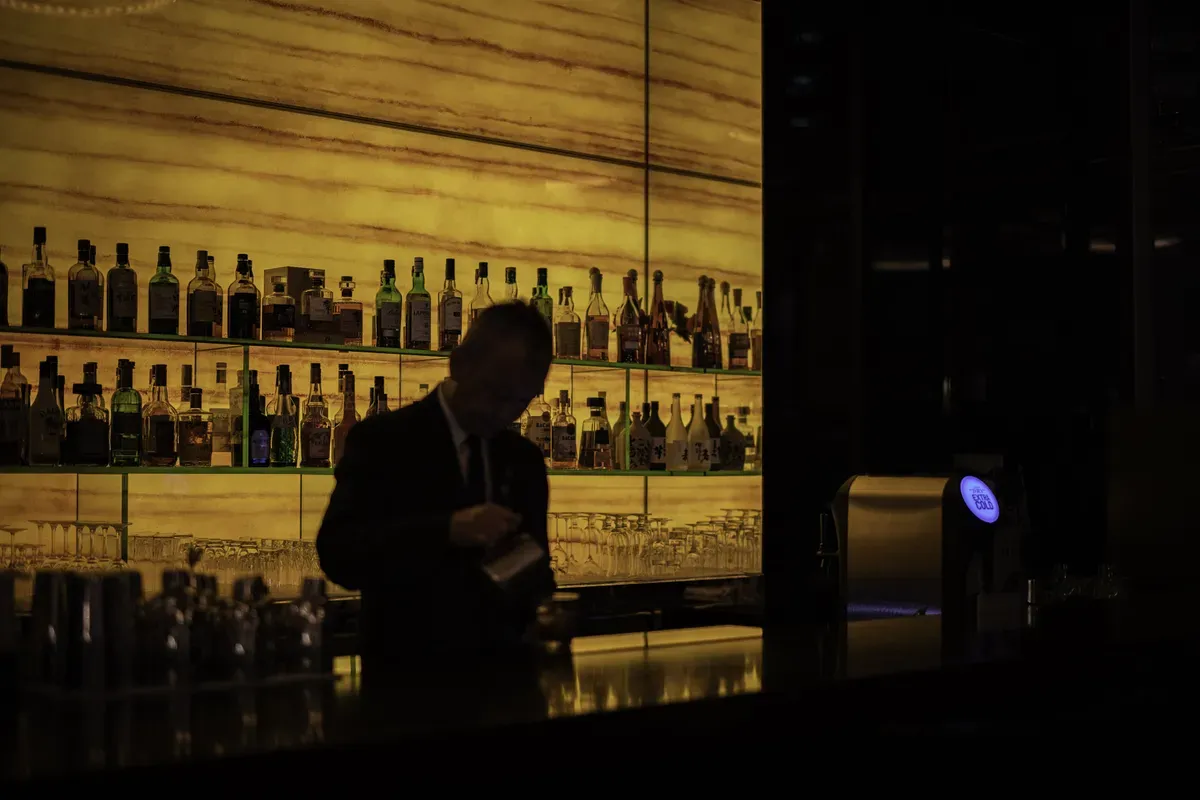 Backlit spirits shelf in a dimly lit bar setting