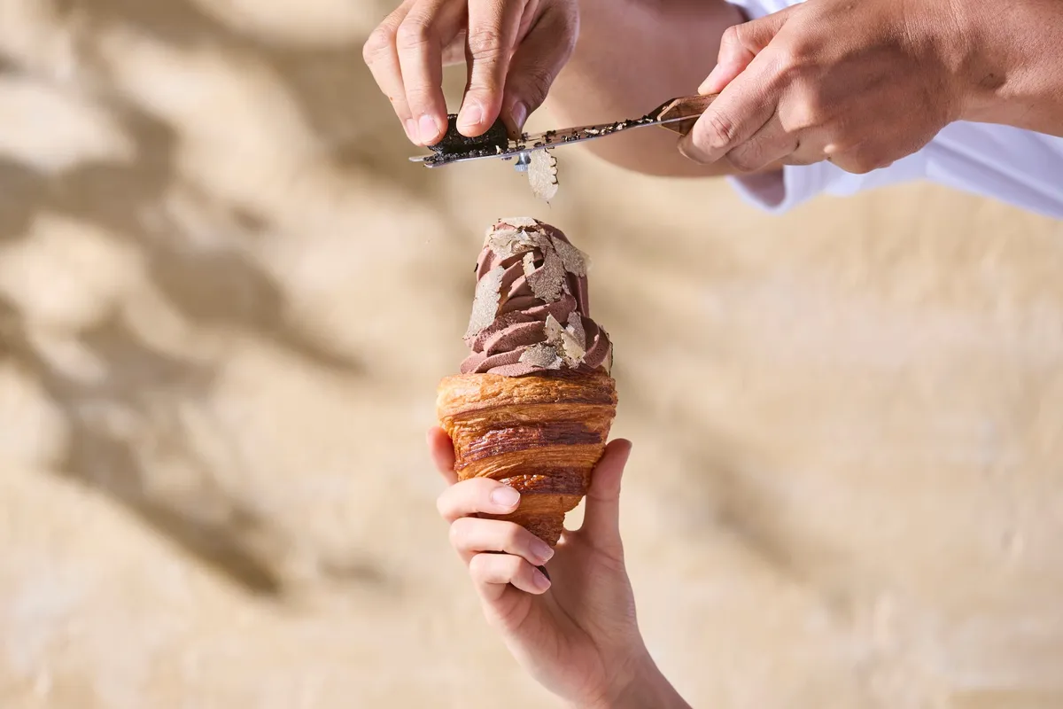 Fresh black truffle being shaved over chocolate soft serve