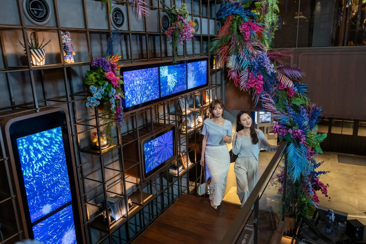 Guests on the stairs surrounded by flower art