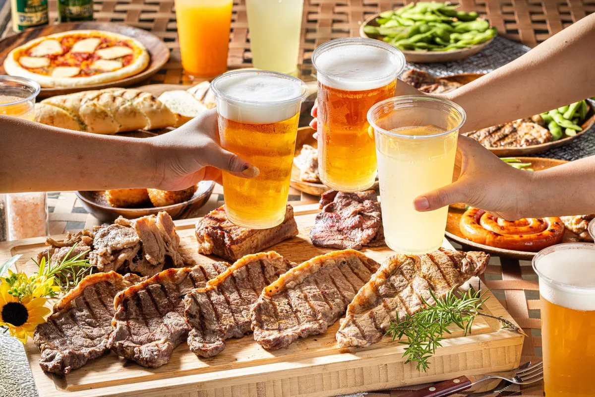 Guests toasting with beers over a barbecue platter
