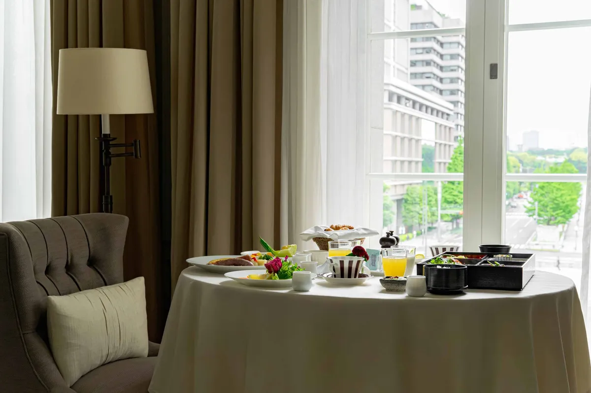 In-room dining table set against a window overlooking the city