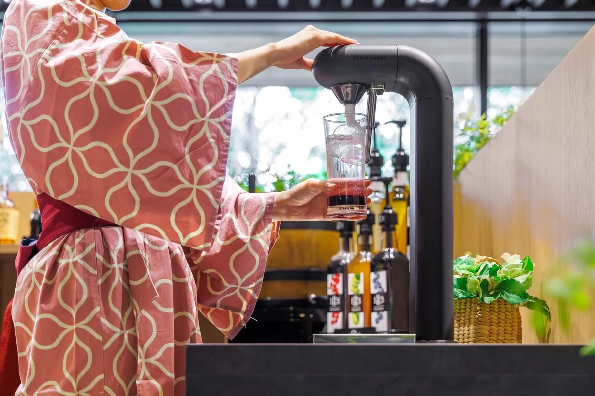 Staff pouring a drink from the Extra Burst carbonation tower