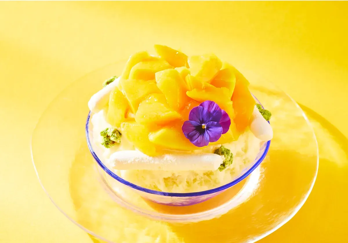 Miyazaki Mango shaved ice with purple floral garnish