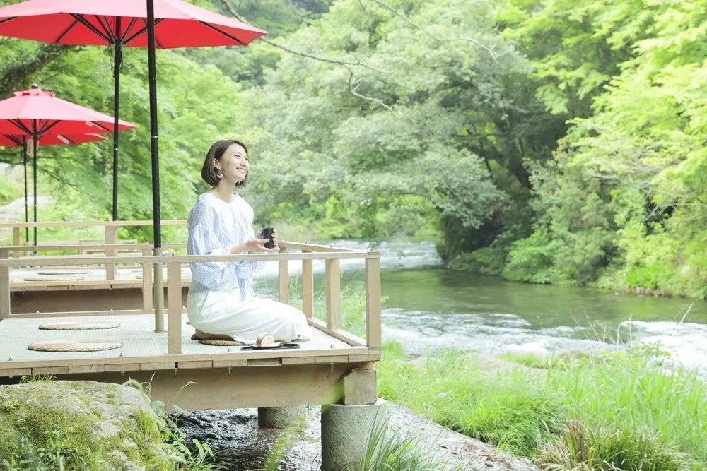 Woman sitting on a riverside wooden platform