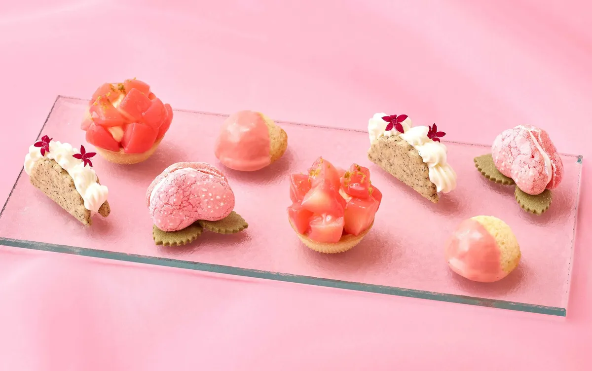 A selection of peach-themed tarts, macarons, and scones