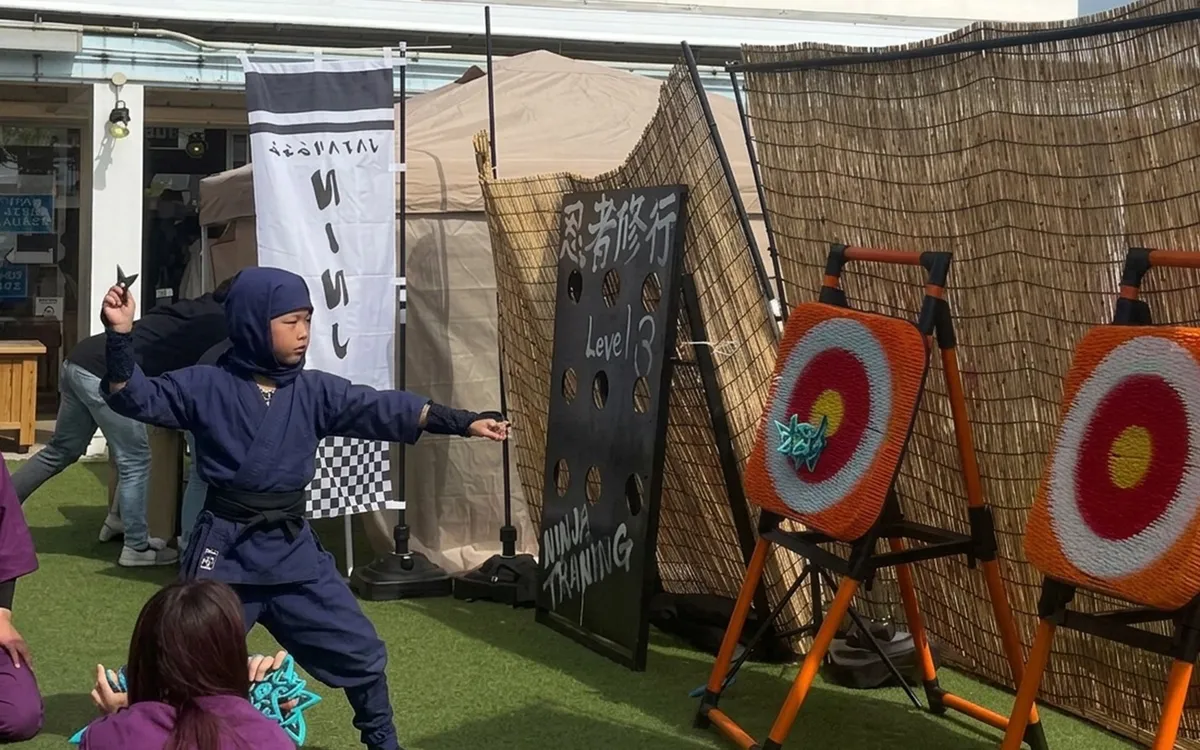 Child in ninja costume throwing shuriken