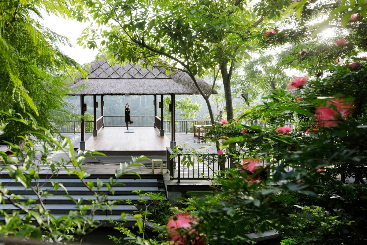 Yoga in a thatched pavilion overlooking the valley
