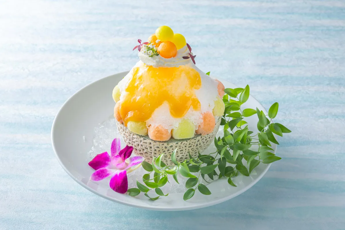 Melon Frappe served in a half-melon shell with fruit spheres and ice cream.