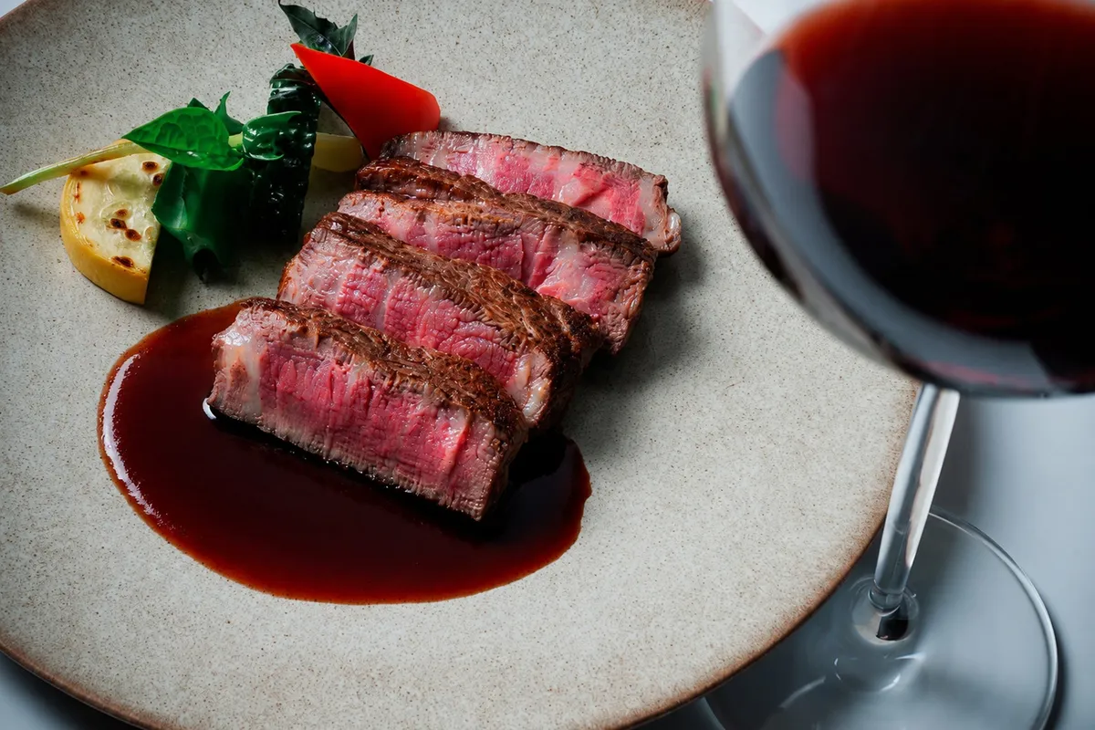 Grilled steak with red wine sauce and a glass of red wine