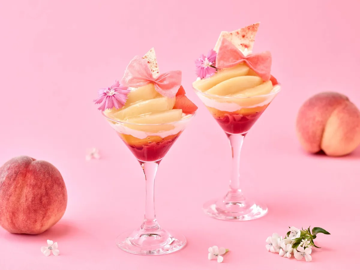 Peach mini parfaits served in stemmed glasses with ribbon tuiles
