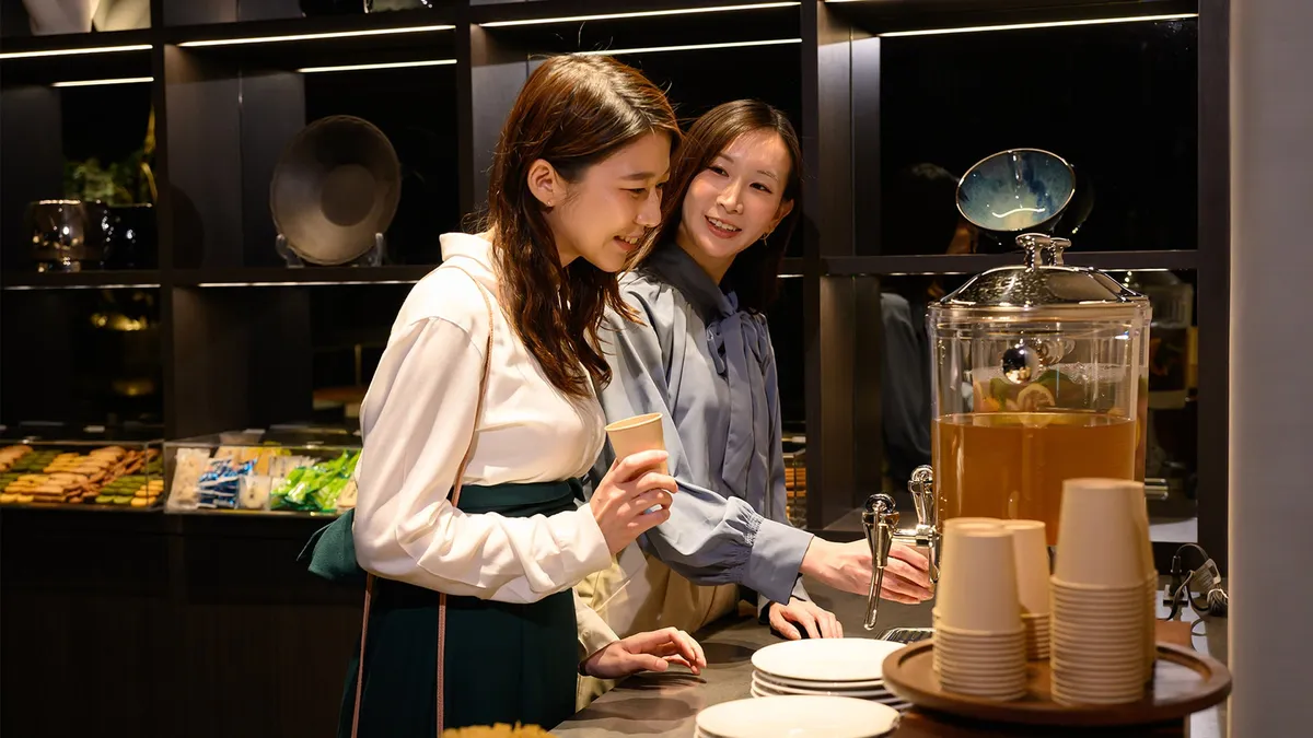 Two guests selecting beverages in the hotel lobby