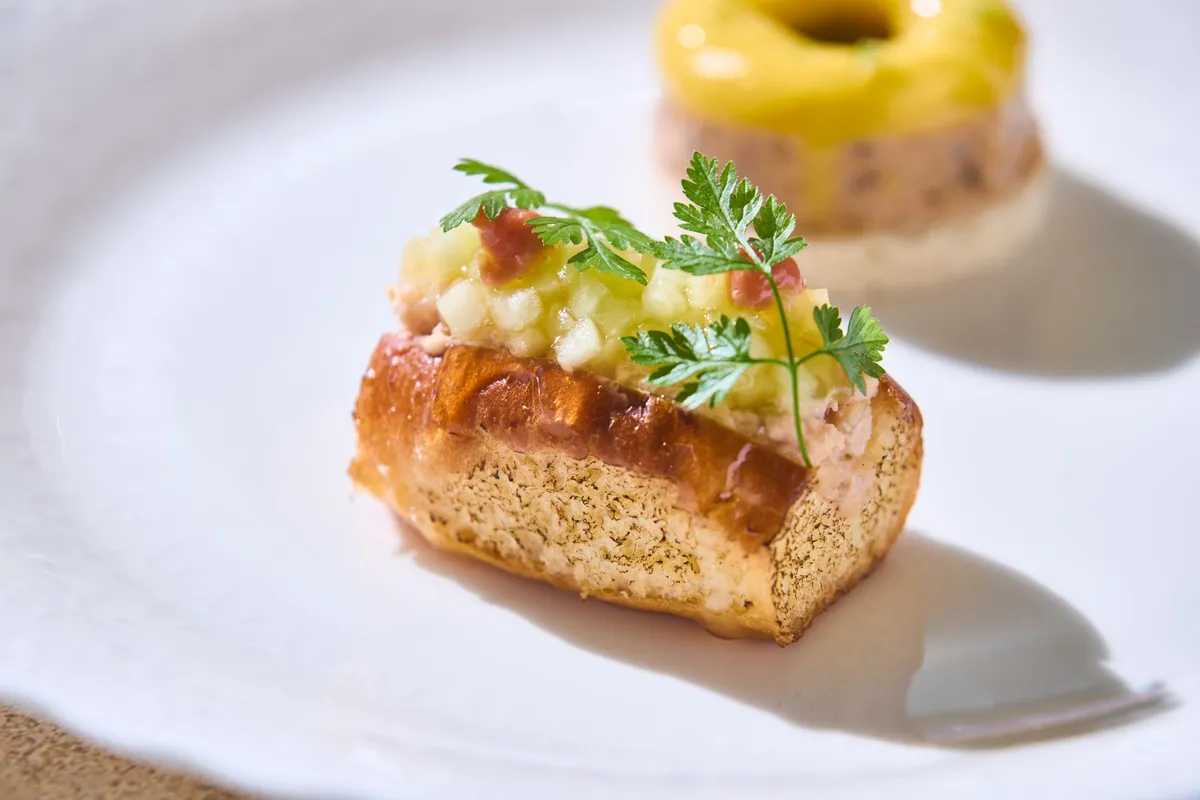 A savory lobster roll topped with diced melon