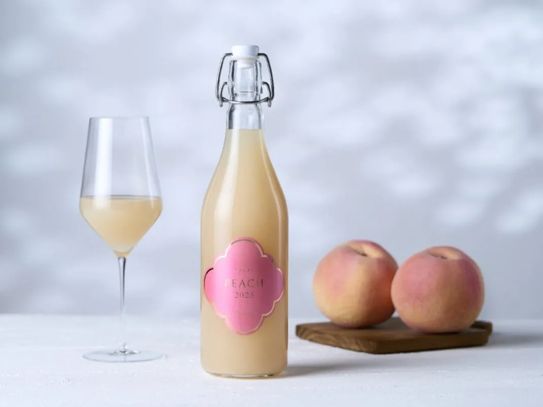 A bottle of Fujiclair Kurano-oto Peach wine with a glass
