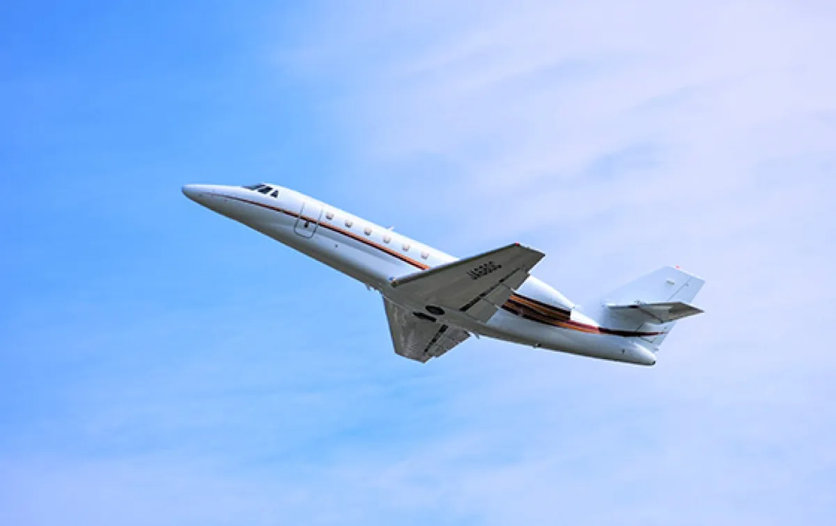A private jet in flight against a blue sky