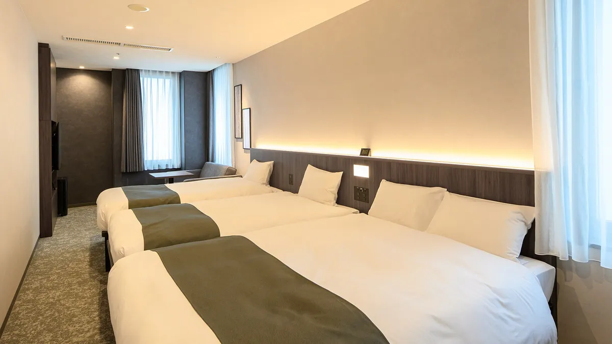 A spacious premium triple room with three beds
