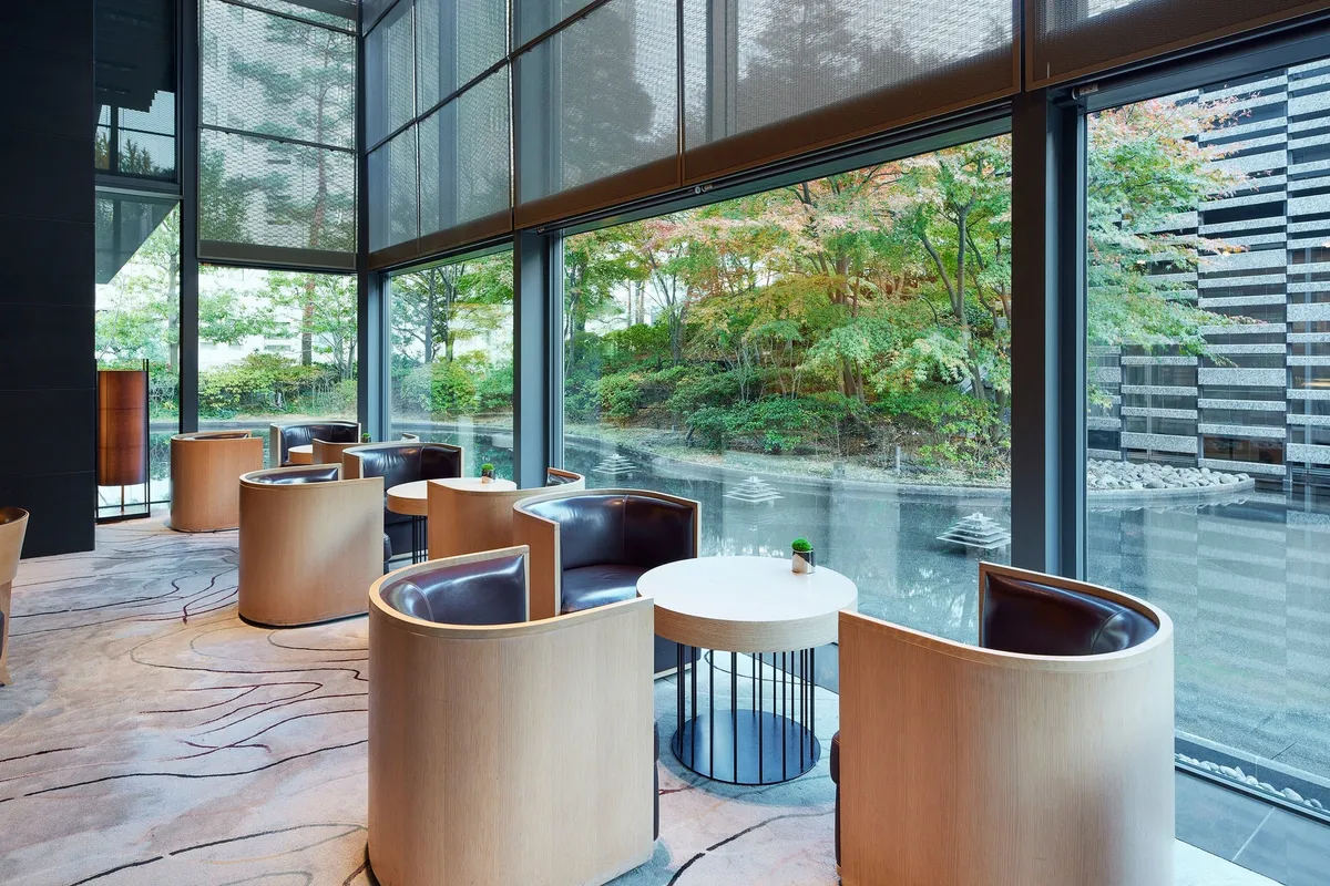 Interior of Lounge ORIGAMI with large windows overlooking a green garden and pond.