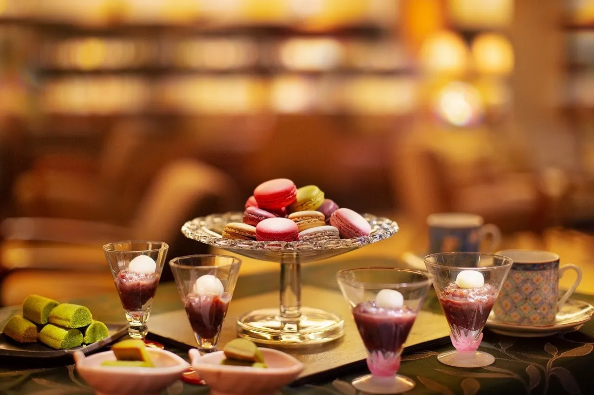 A selection of macarons and small desserts on a glass stand