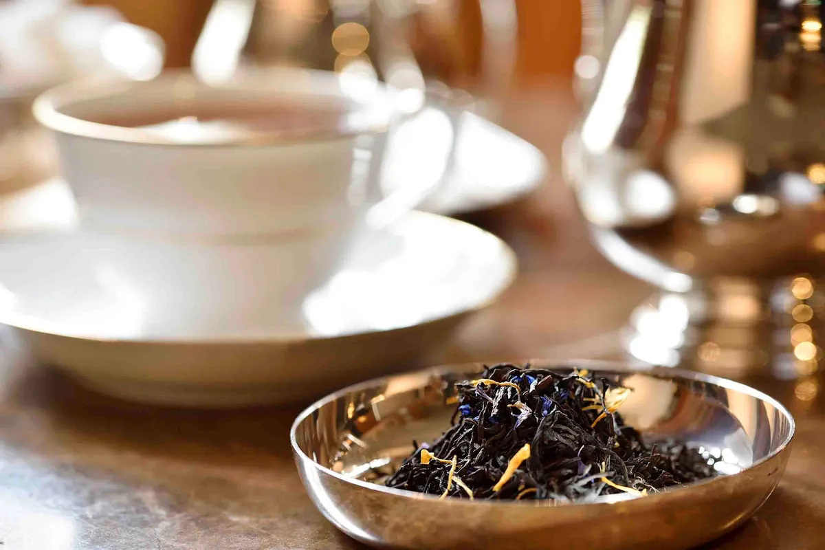 Loose tea leaves and a white teacup